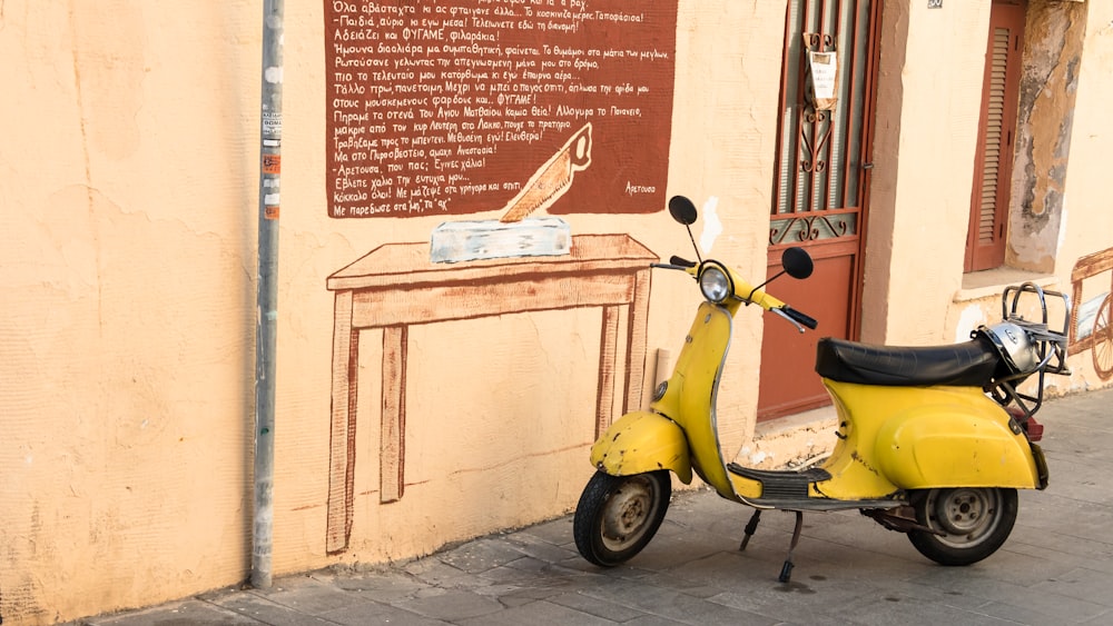 yellow moped parked near brown concrete building