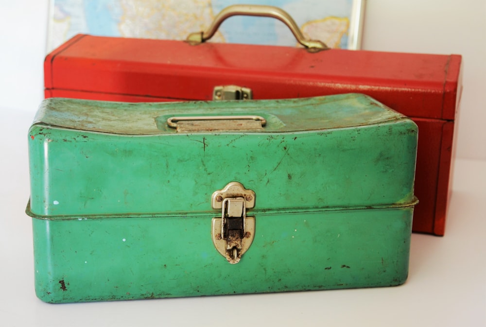 two rectangular green and red tool cases on white surface