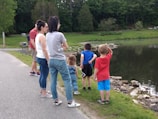 Children gathered around a naturalist exploring a pond ecosystem at Burris Park.