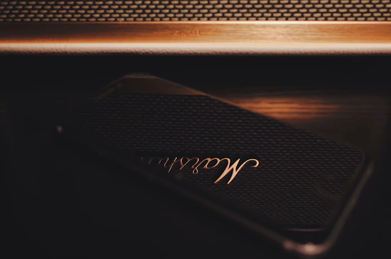 A sleek smartphone displaying the rajputrax app interface with dark glassmorphism theme and gold accents.