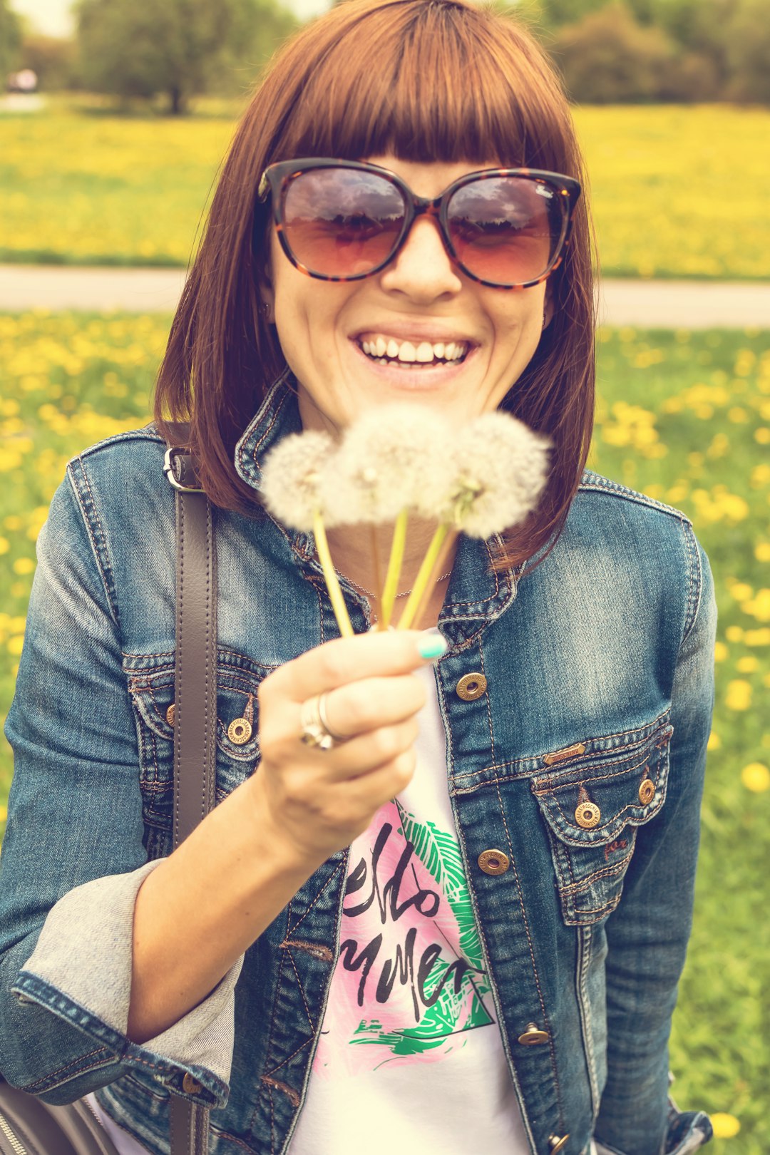 woman holding dandelion flowers