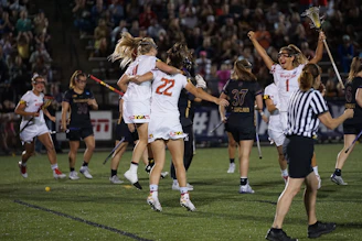 A group of young female water polo players celebrating a hard-earned victory together.