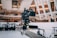 A professional video camera is mounted on a mechanical arm within a modern architectural setting. The background features sleek, curved structures with visible balconies and people observing the scene.