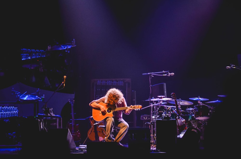 man playing guitar on stage