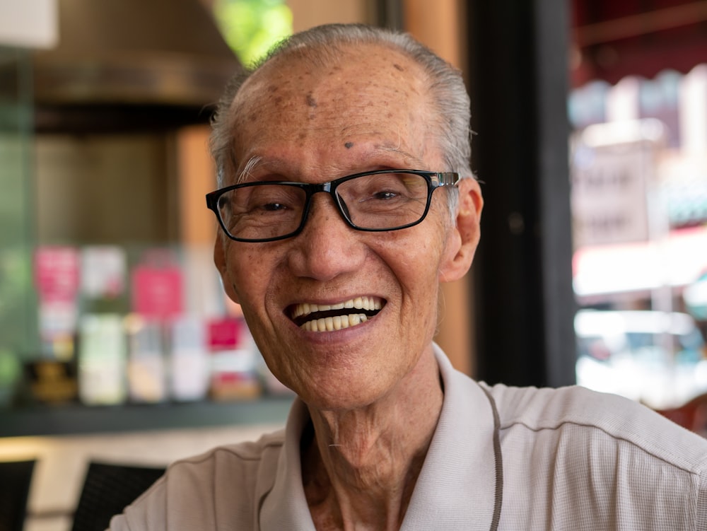 uomo sorridente che indossa occhiali all'interno della stanza