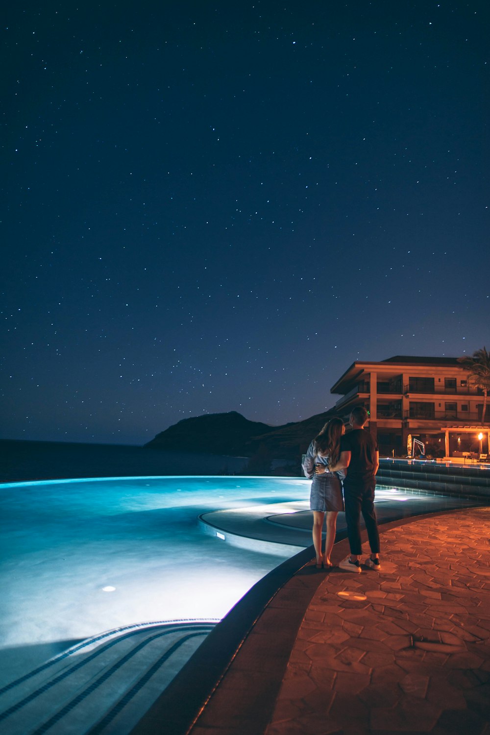 Mann und Frau stehen in der Nähe des Pools