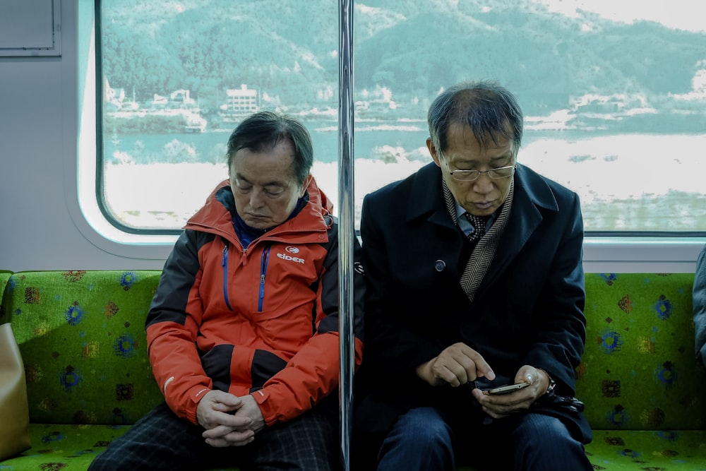 two men sitting inside passenger vehicle