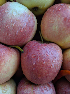 Close-up of a chilled Liquid Apple bottle with condensation, surrounded by fresh apples.