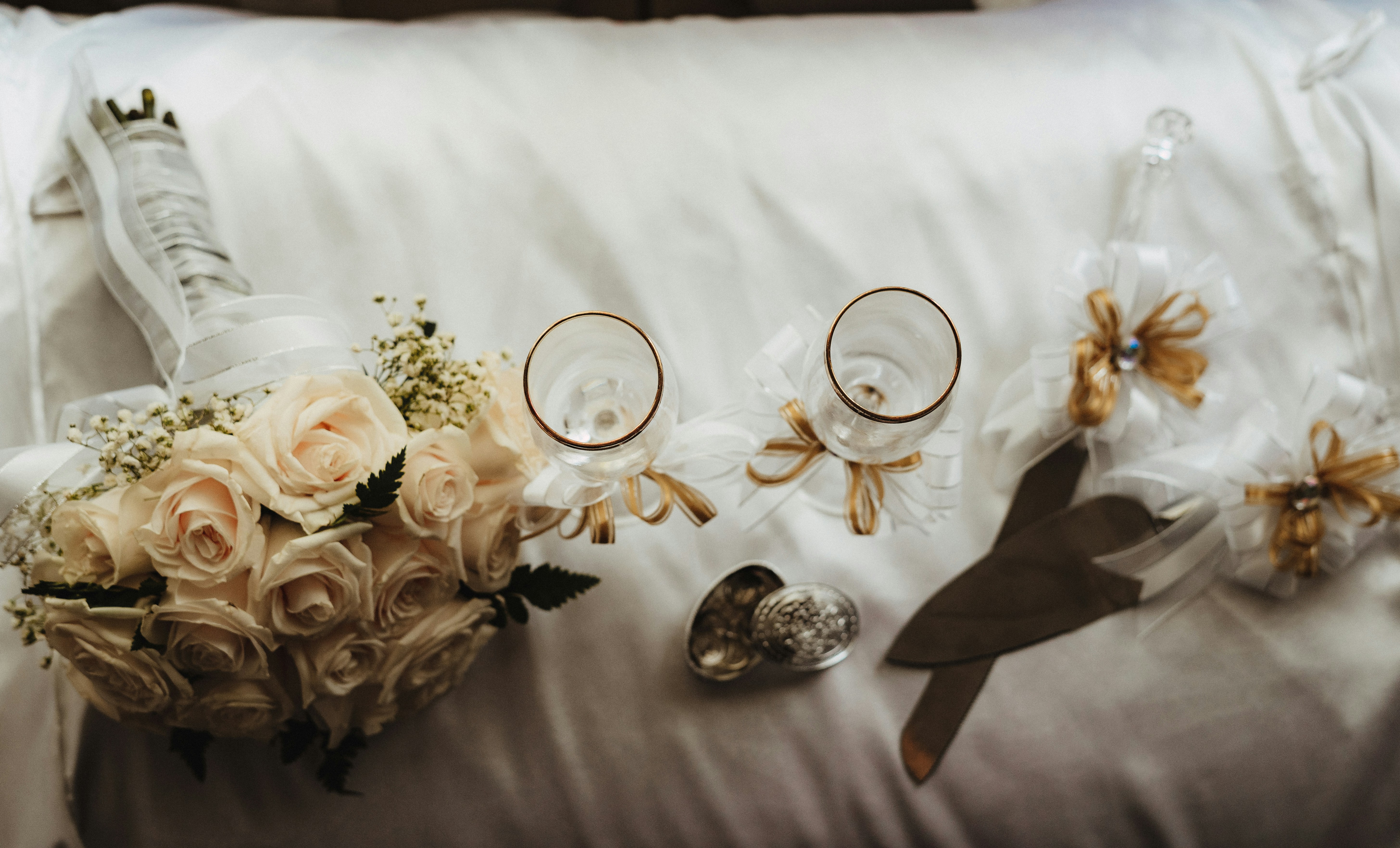 flat lay photography of wedding bouquet, ring, coin, cake slicer, and server