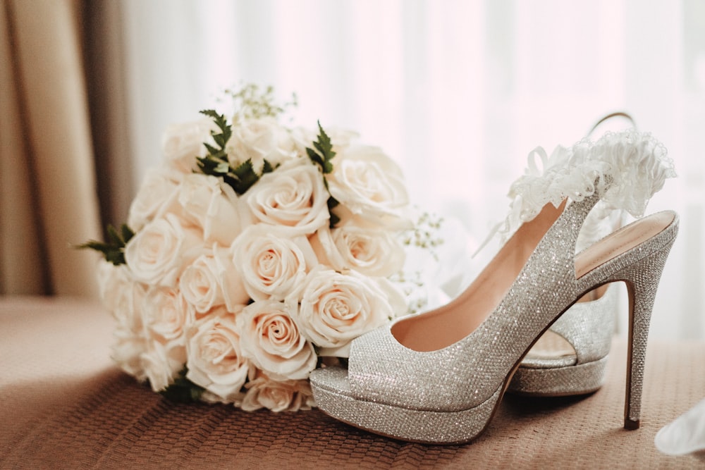 white rose bouquet beside grey leather stiletto