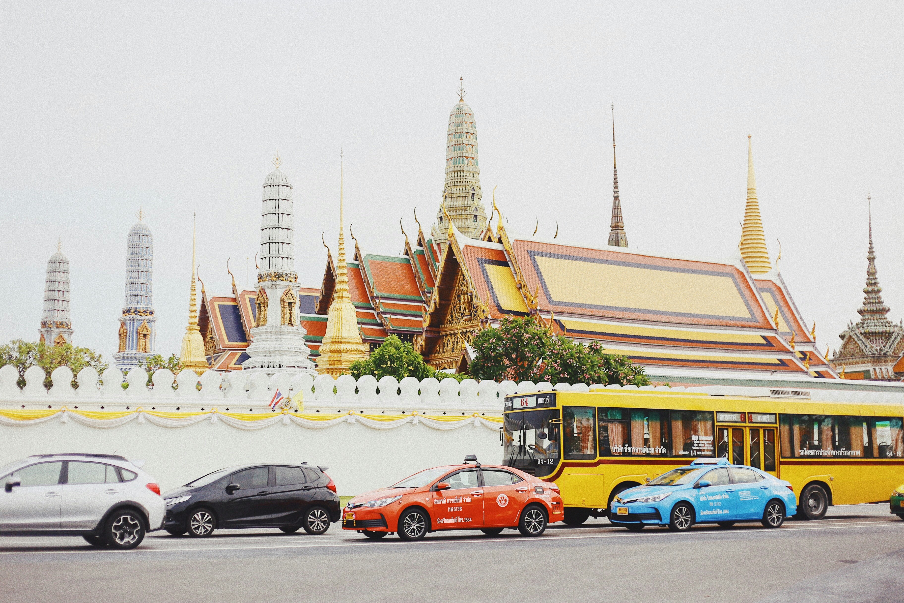 assorted-color vehicles parked near wall during daytime