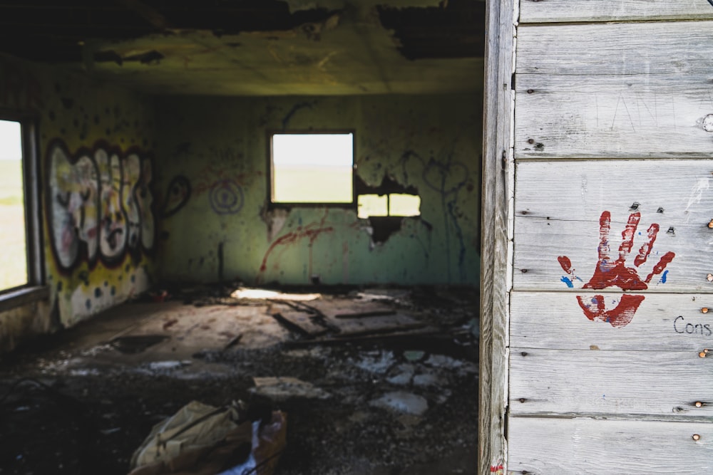 a room with graffiti on the walls and a hand print on the door