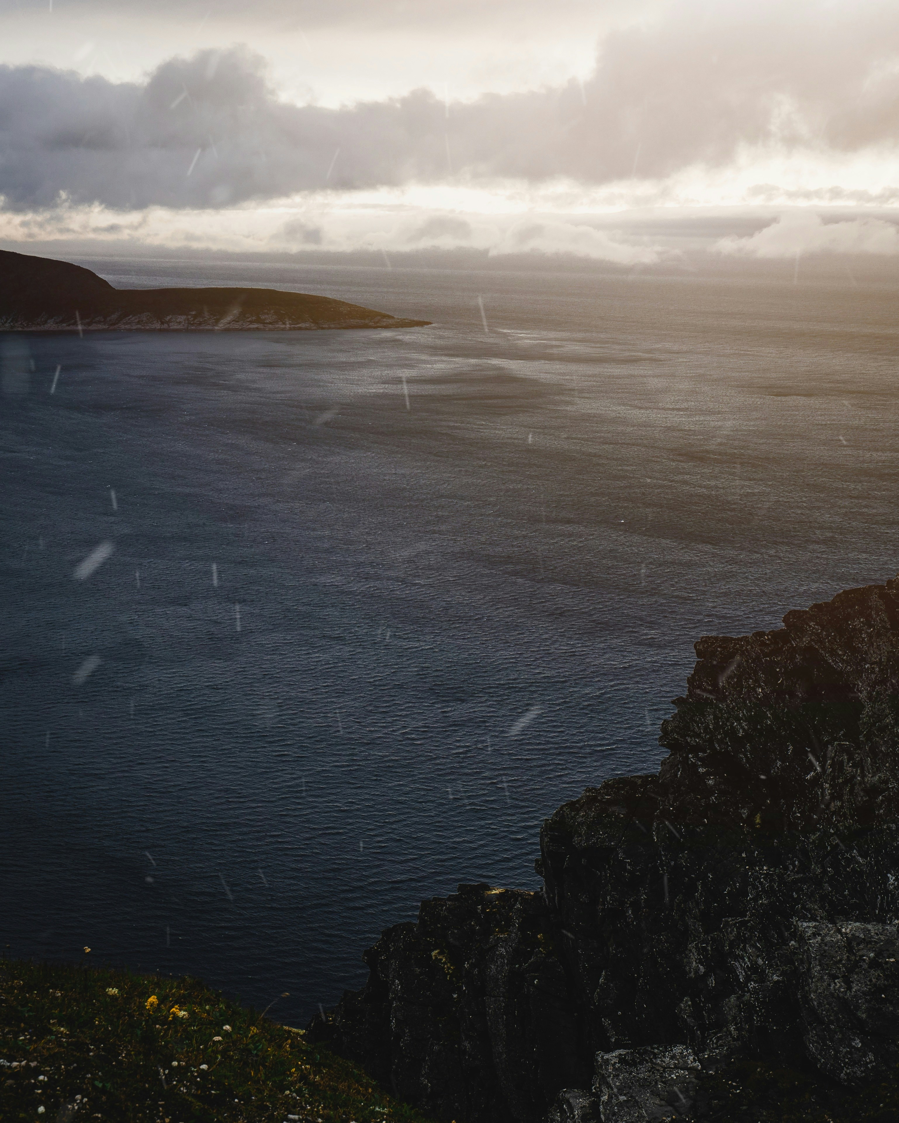 beach cliff viewing calm sea under gray skies
