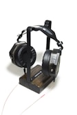 Side view of Koira headset resting on a minimalist stand.