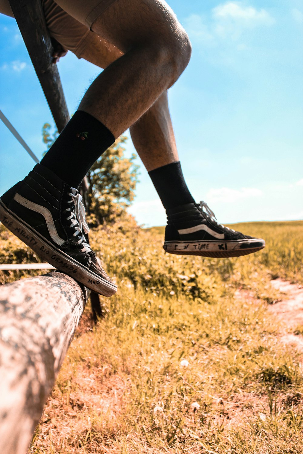Tegne forsikring hård pop person wearing black socks and black-and-white Vans shoes sitting on black  rod photo – Free Clothing Image on Unsplash