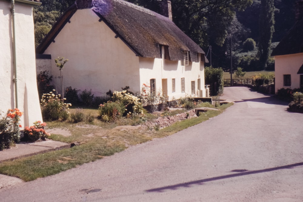 white and brown house beside paved road