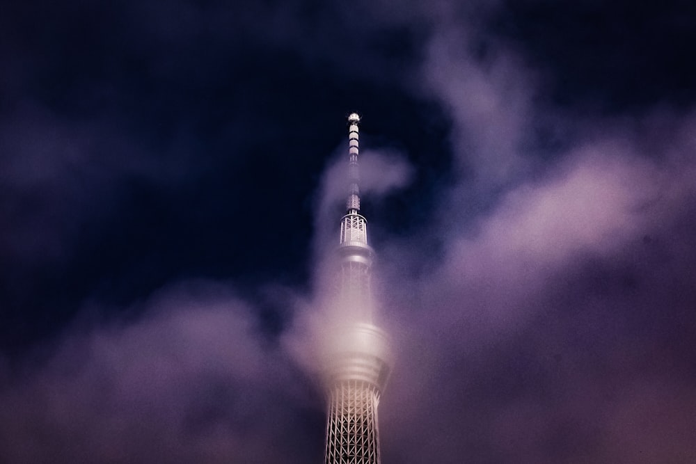 gray concrete tower surrounded with clouds