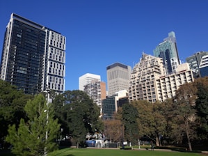 A futuristic cityscape blending green parks with sleek smart buildings under a clear sky.