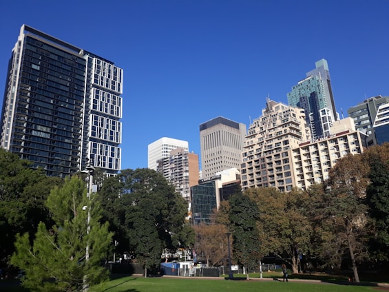 A futuristic cityscape blending green parks with sleek smart buildings under a clear sky.