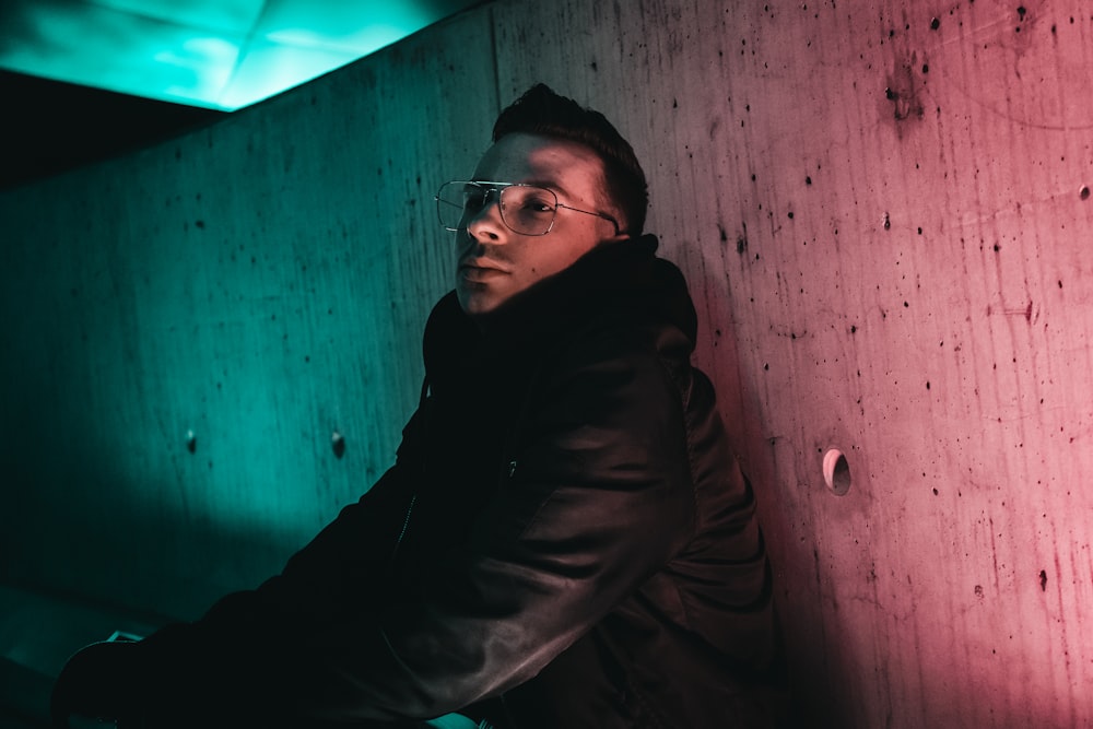 man leaning against concrete wall