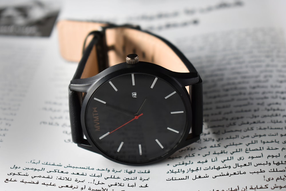 round black analog watch reading at 4:05