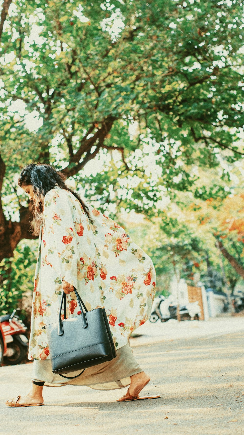 woman walking while holding black leather handbag