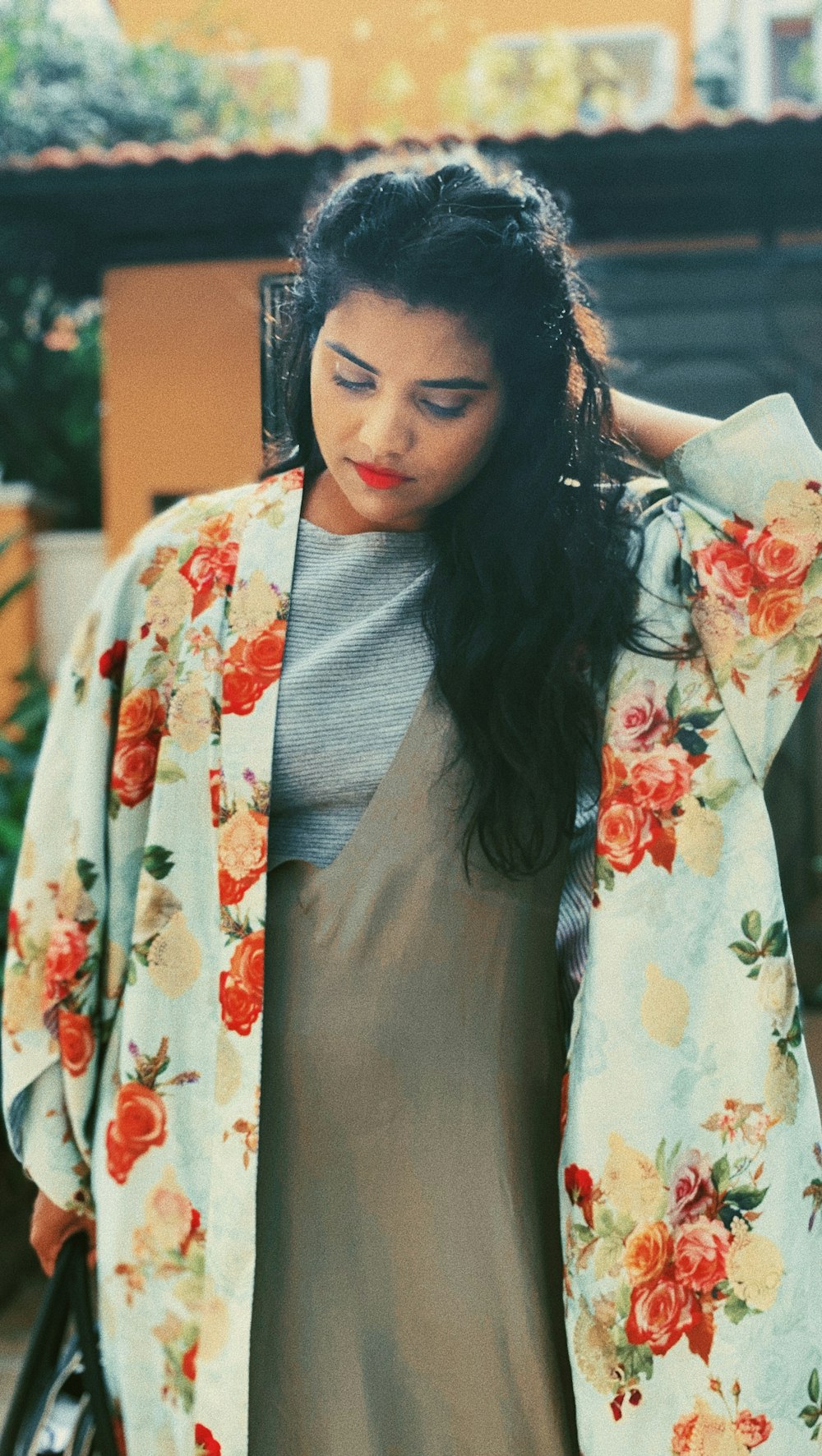 woman looking downwards while holding the back of her head with her left hand