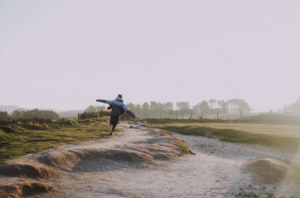 person wearing jacket running on grass field