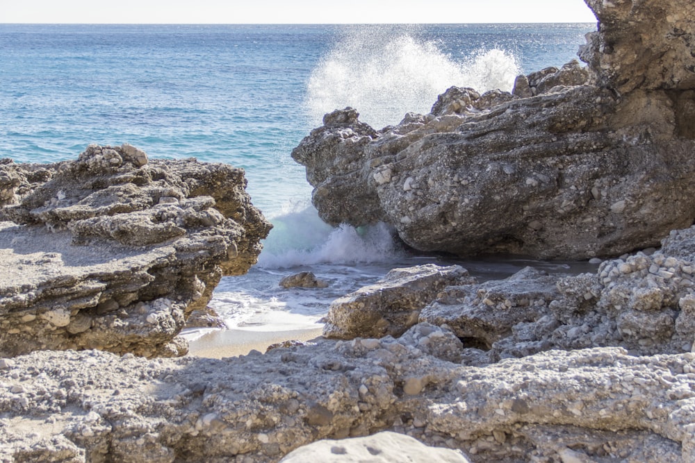 brown rocks across body of water