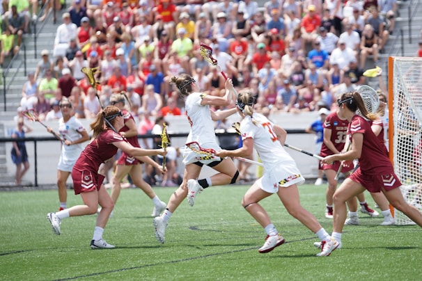 A dynamic action shot of the women's lacrosse team during a game.