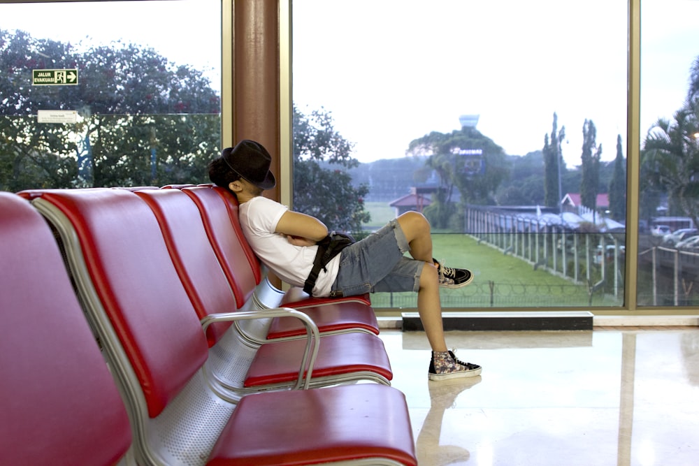 unknown person sitting on red gang chair indoors