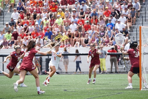 A dynamic action shot of a women's lacrosse game.