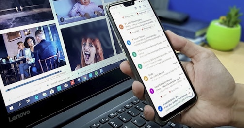 person using smartphone and laptop computer