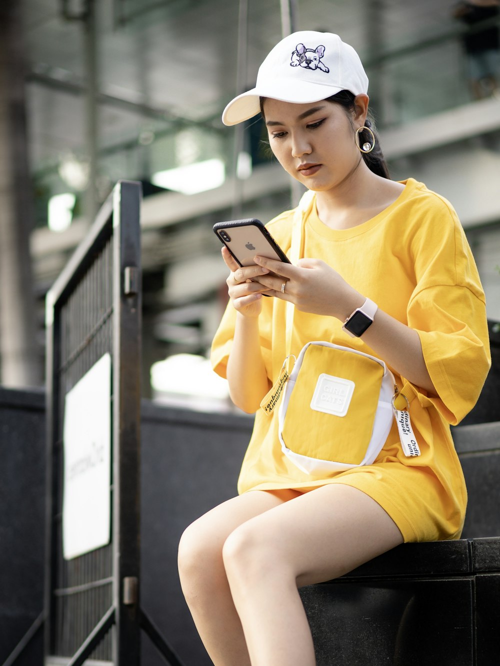 woman sits on chair while holding iPhone