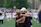 Happy group of kids and parents gathered around a football field celebrating after a game.