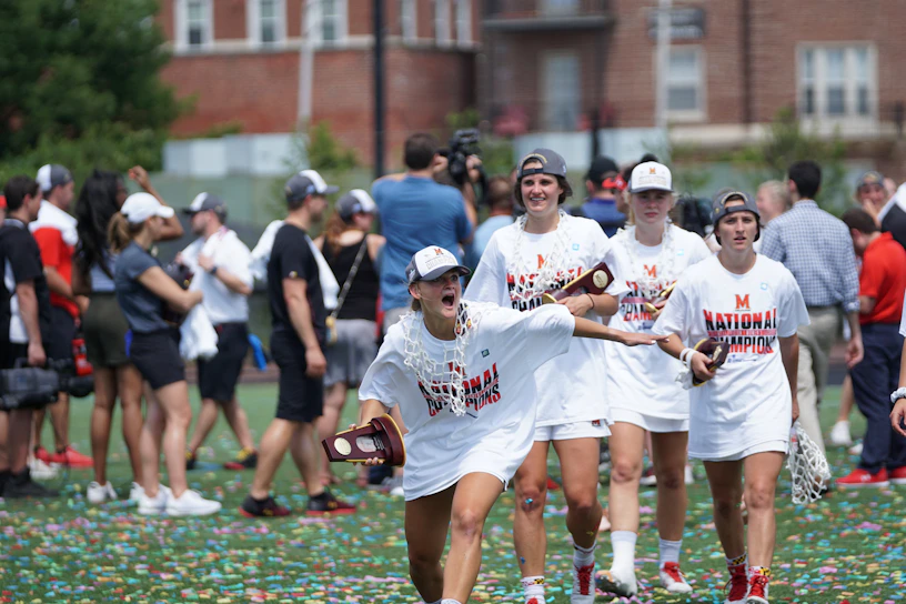 A vibrant group of young athletes wearing double down hats and shirts, celebrating a victory on the field.
