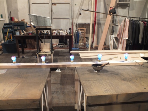 A cozy workspace with colorful handmade crafts and tools scattered around, showing the creative process.