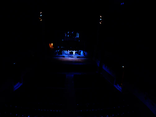 Sora Trinity players intensely focused during a live match under dramatic stage lighting.