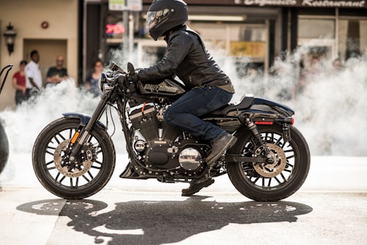 person wearing jacket and helmet riding motorcycle