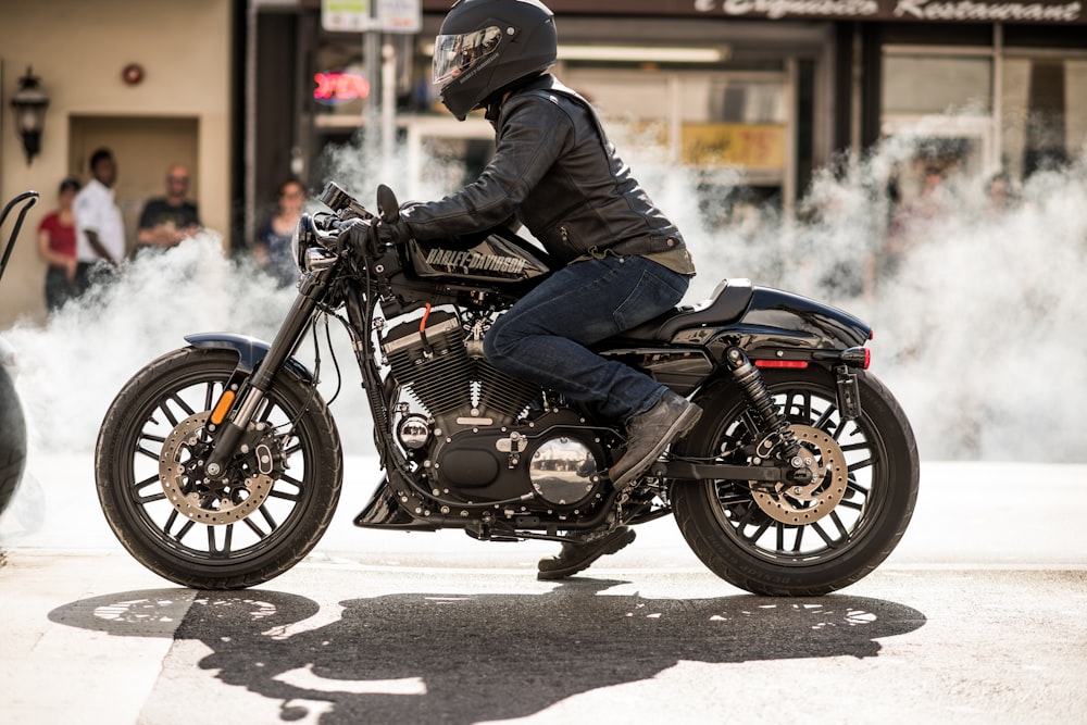 Persona con chaqueta y casco que conduce motocicleta