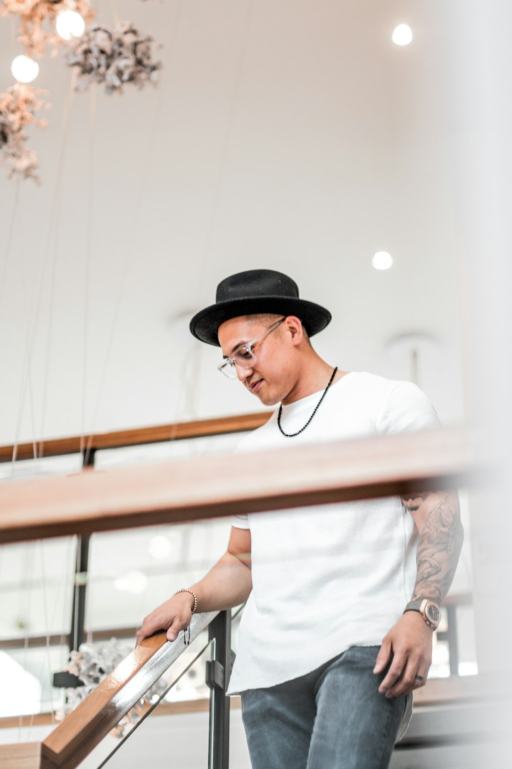 man in black hat and white t-shirt standing on staircase