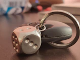 Close-up of a sleek 3D printed car keychain with neon blue highlights on a dark background