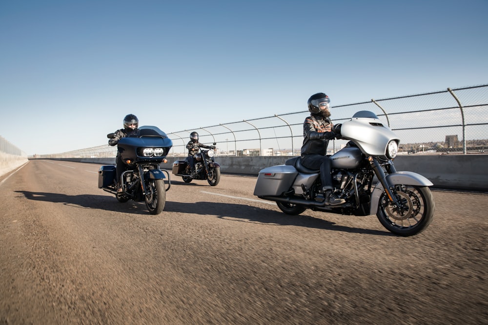 three men riding touring motorcycles