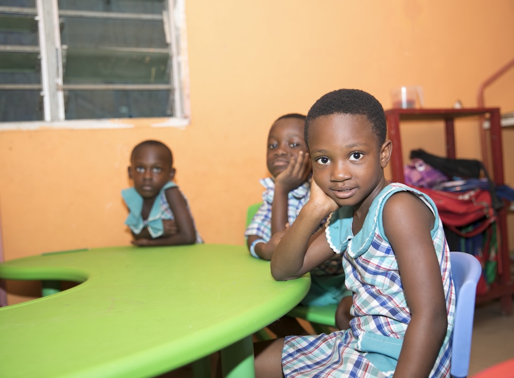 three children sitting by the table