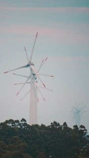 Wind turbine blades turning gently against a clear horizon