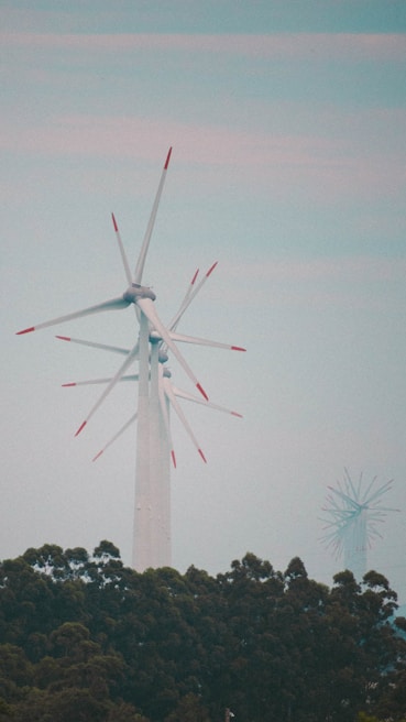 Wind turbines turning gently against a blue sky with clouds