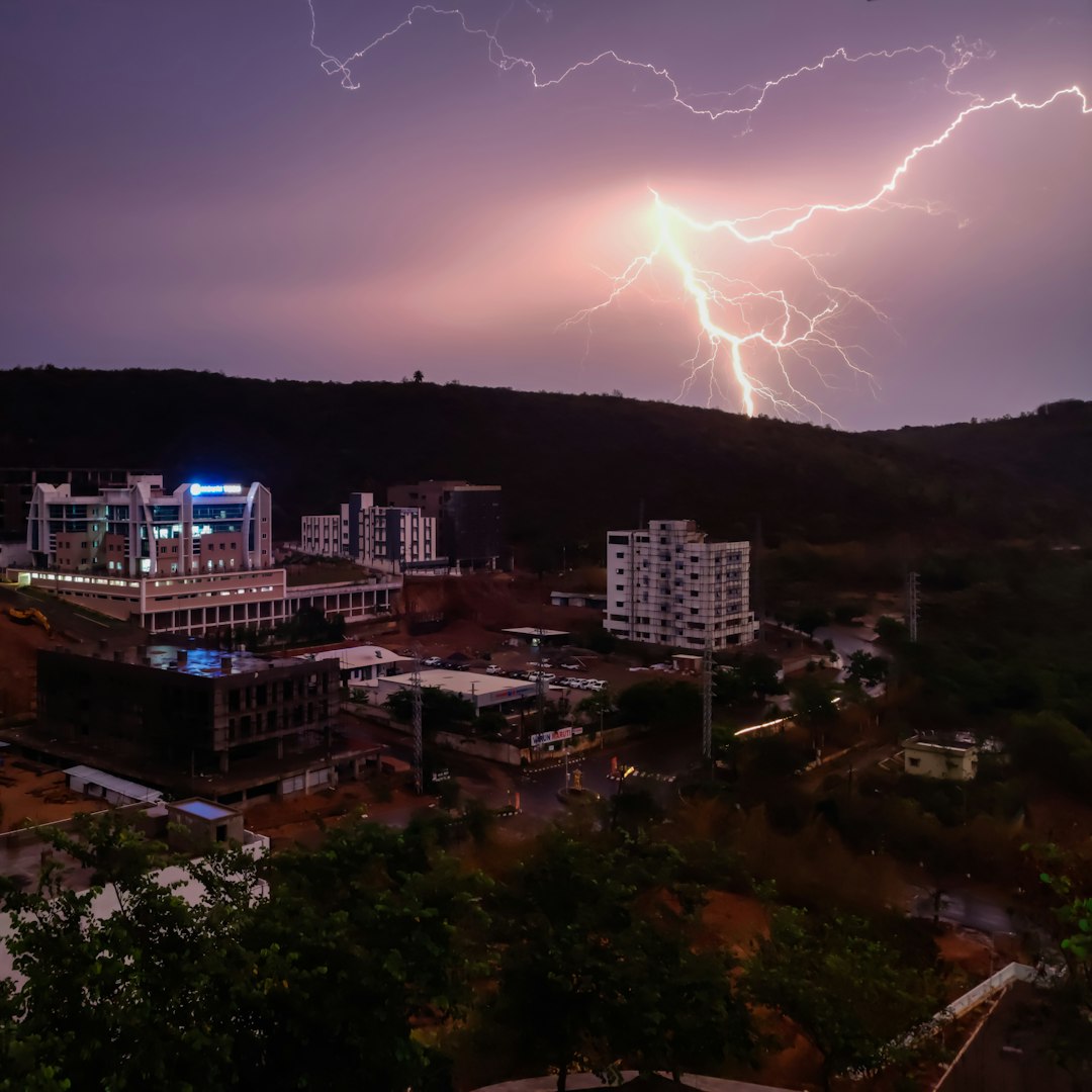 lightning on mountain near buildings