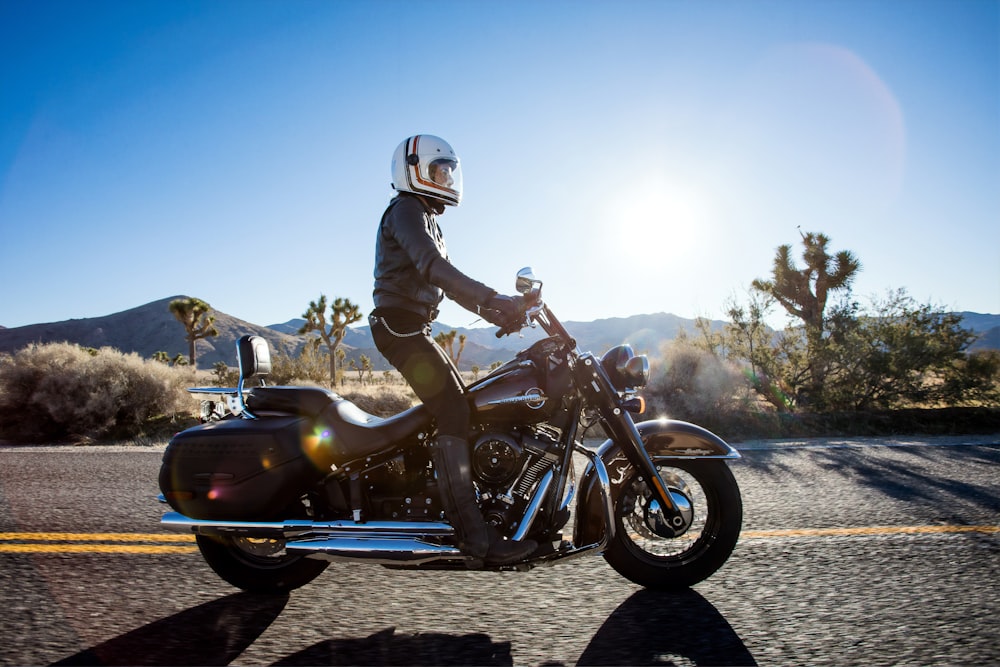 Mann auf schwarzem Cruiser-Motorrad auf der Autobahn