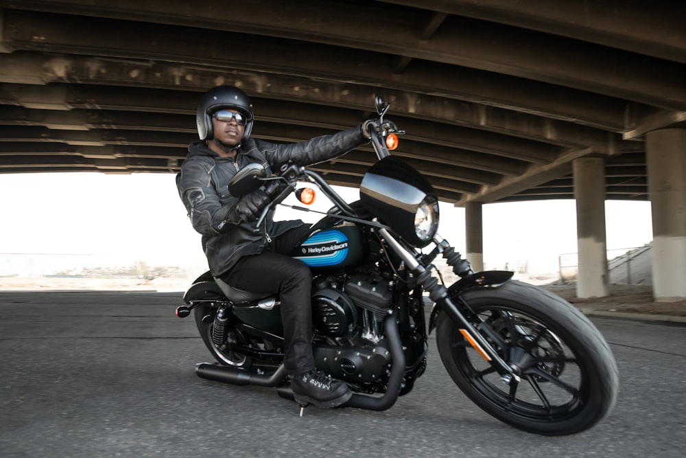 homme conduisant une moto noire