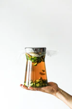 Close-up of hands sealing a glass jar filled with preserved vegetables, highlighting care and detail.